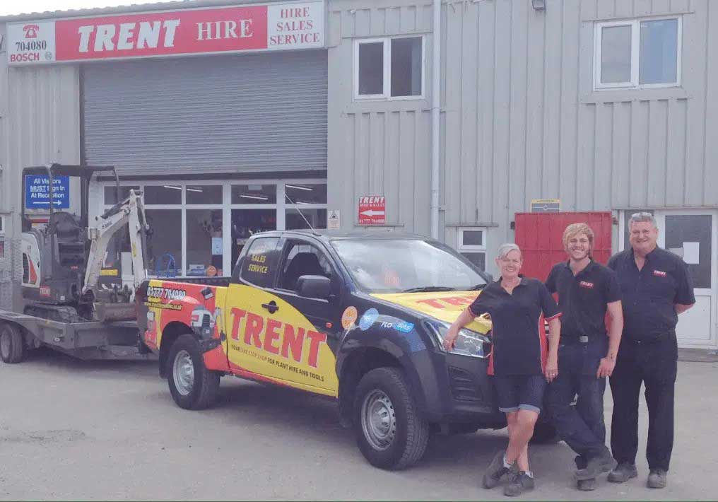 Trent Hire team standing beside a branded service vehicle in front of their building