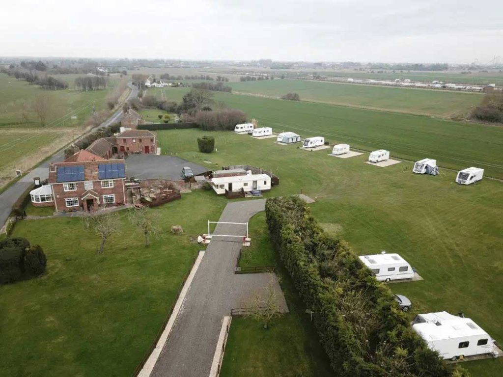 Aerial view of a countryside caravan park with farm buildings and open fields