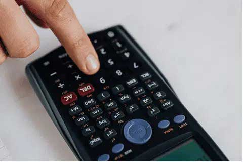 Close up of a person using a scientific calculator