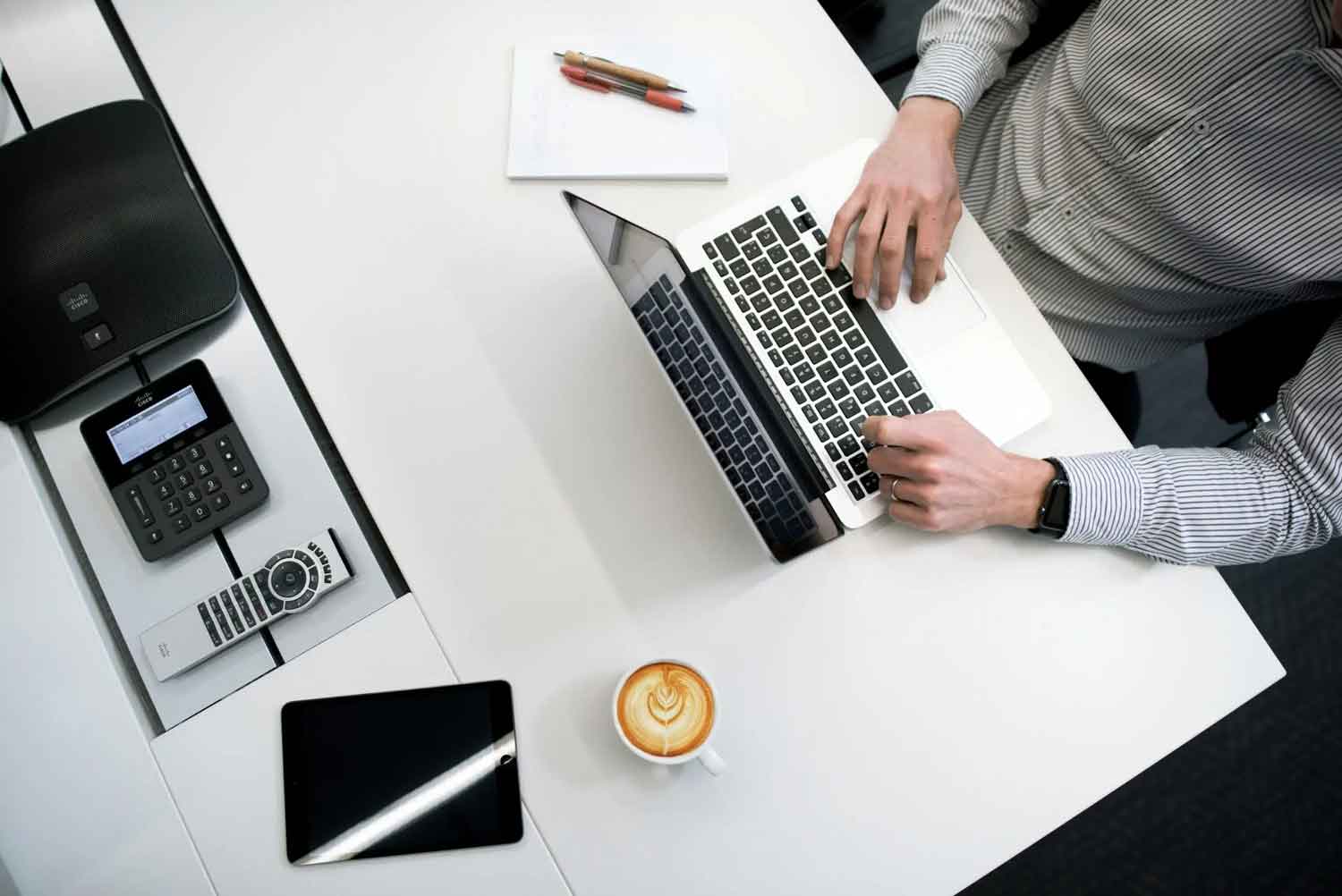 house-building-800x400 Top view of a person working on a laptop at a modern desk with coffee and office devices