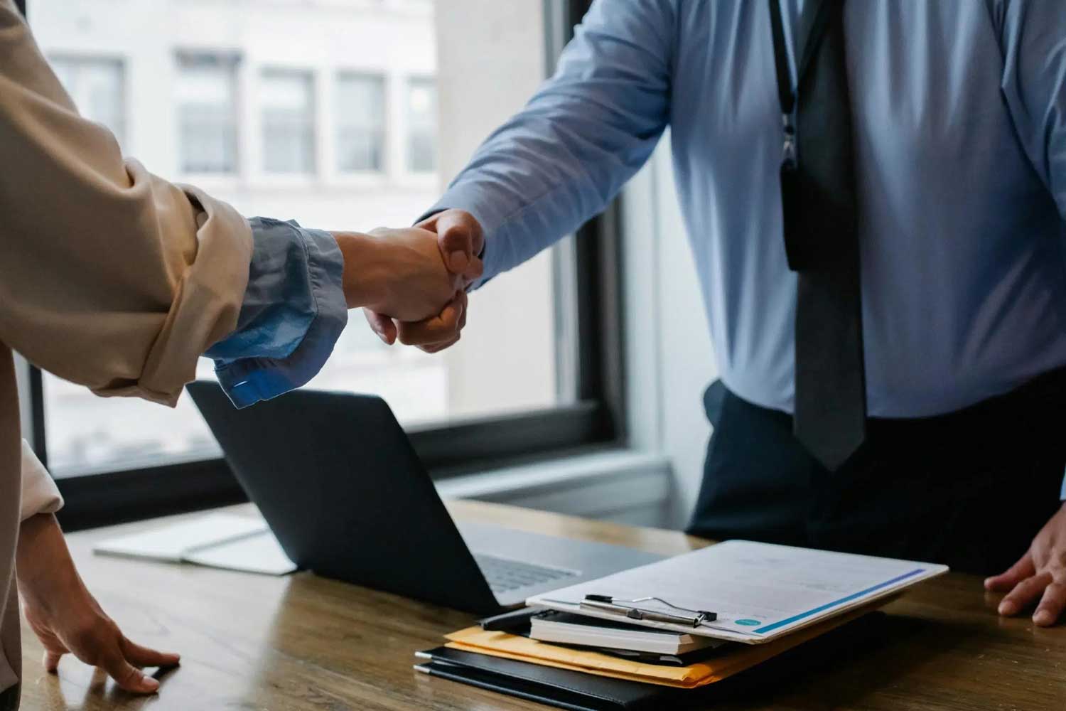 house-building-800x400 Two professionals shaking hands over a desk in an office setting