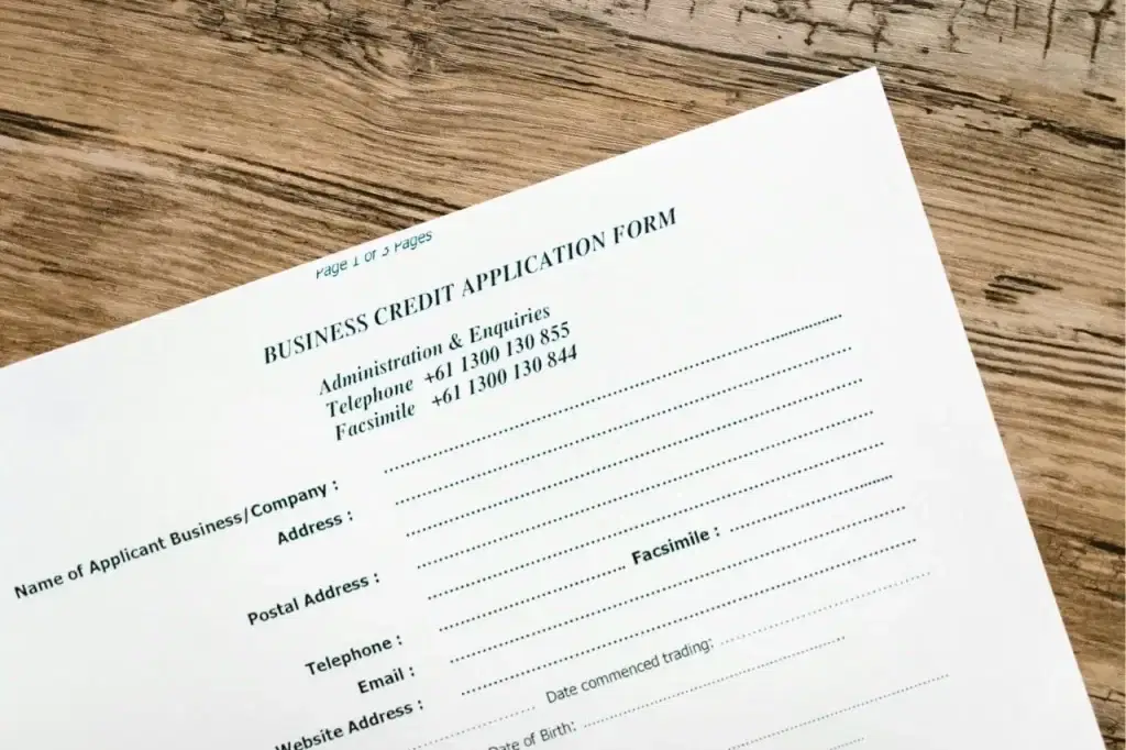 Credit application form lying on a rustic wooden desk surface
